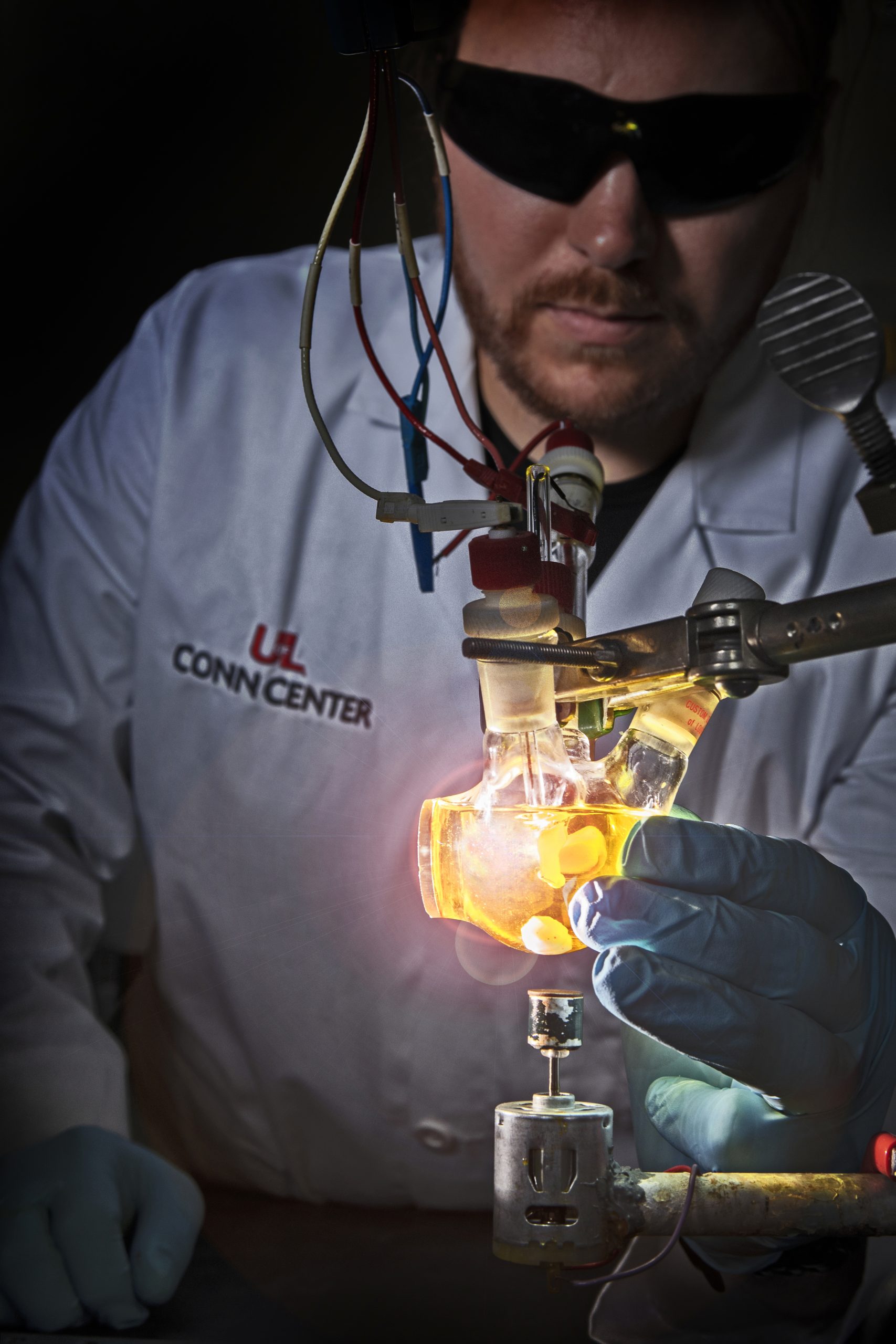 Researcher in lab coat holding a lightbulb