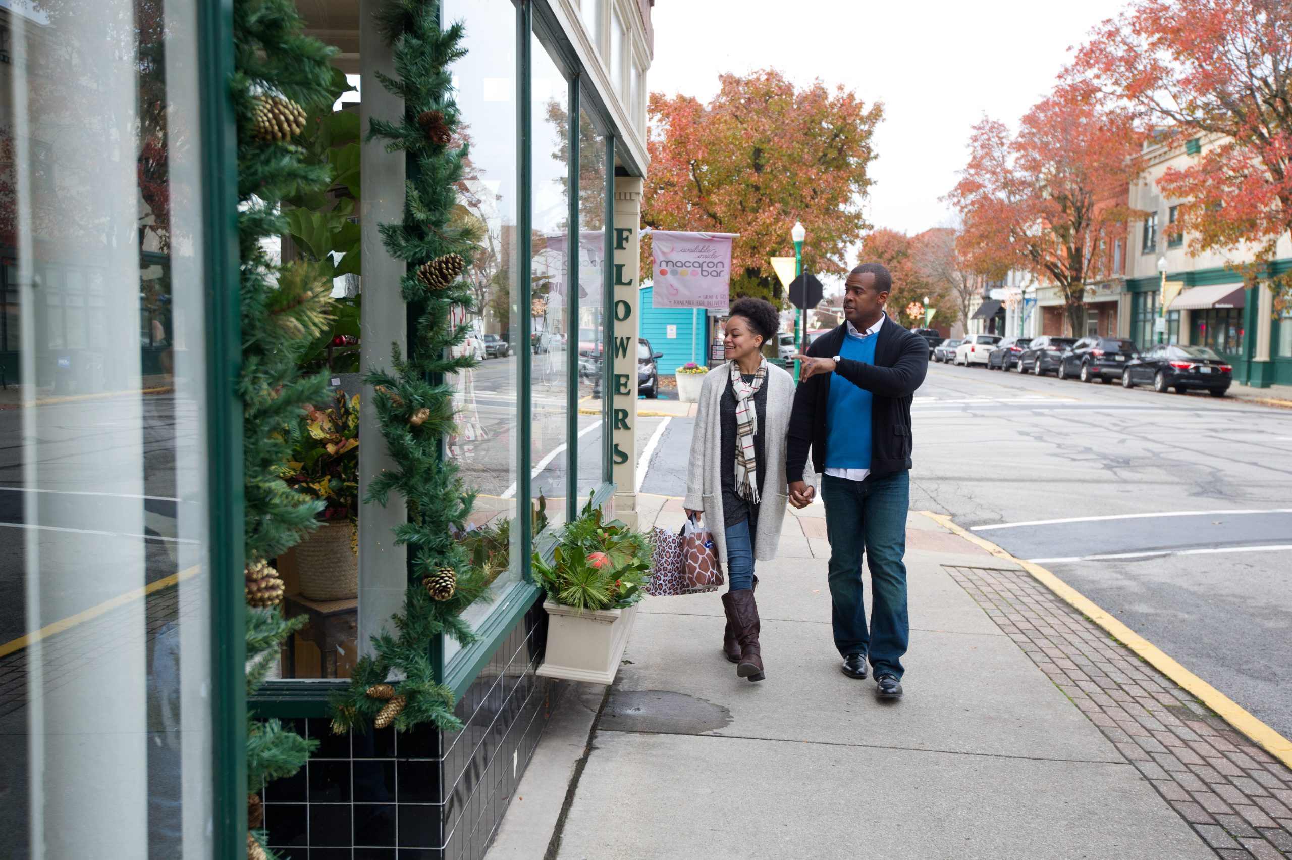 Two people holding hands window shopping