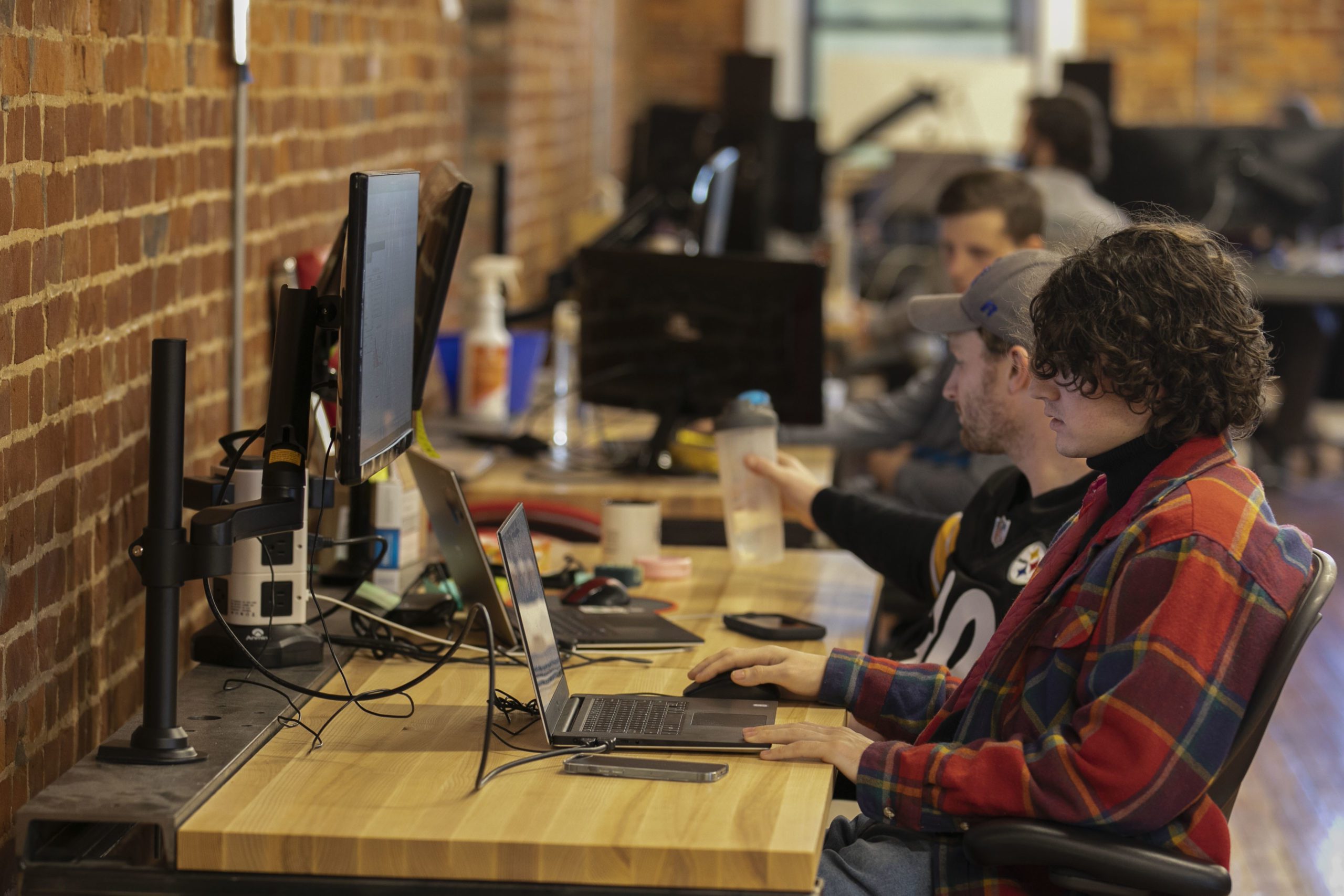 A team of trendy looking young people sitting at computers.