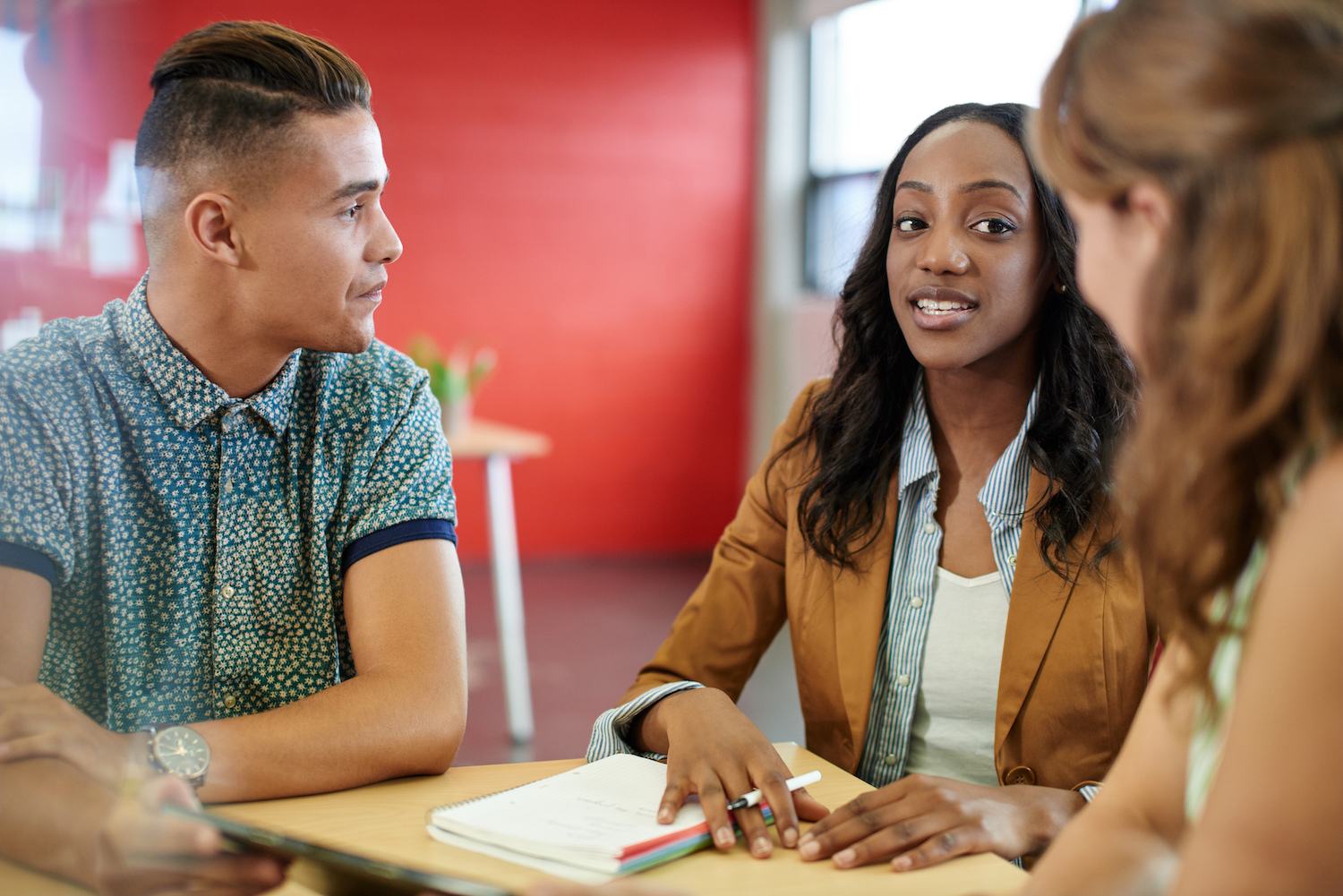 a group of young professionals conversing around a table