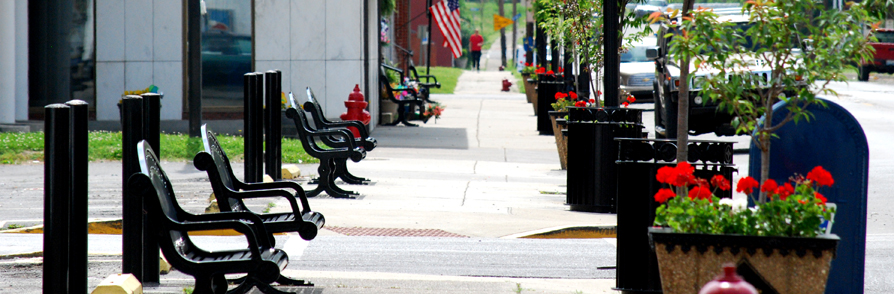 Downtown Spencer County walkway with benches and flowers